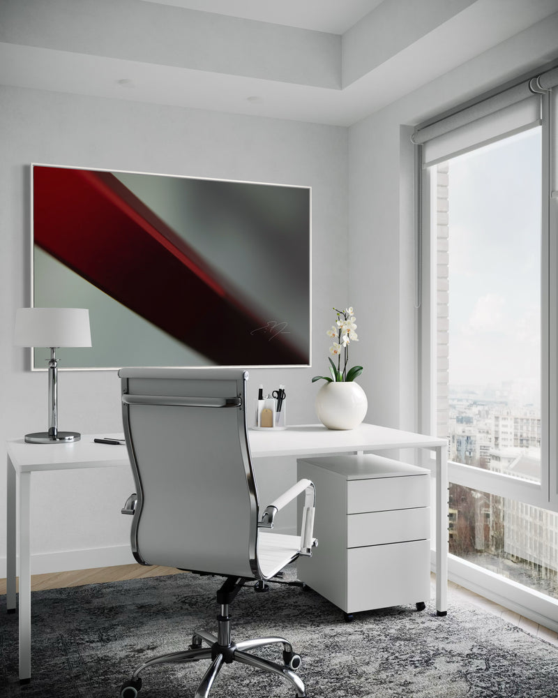 Modern office setup with a desk, chair, and abstract painting.